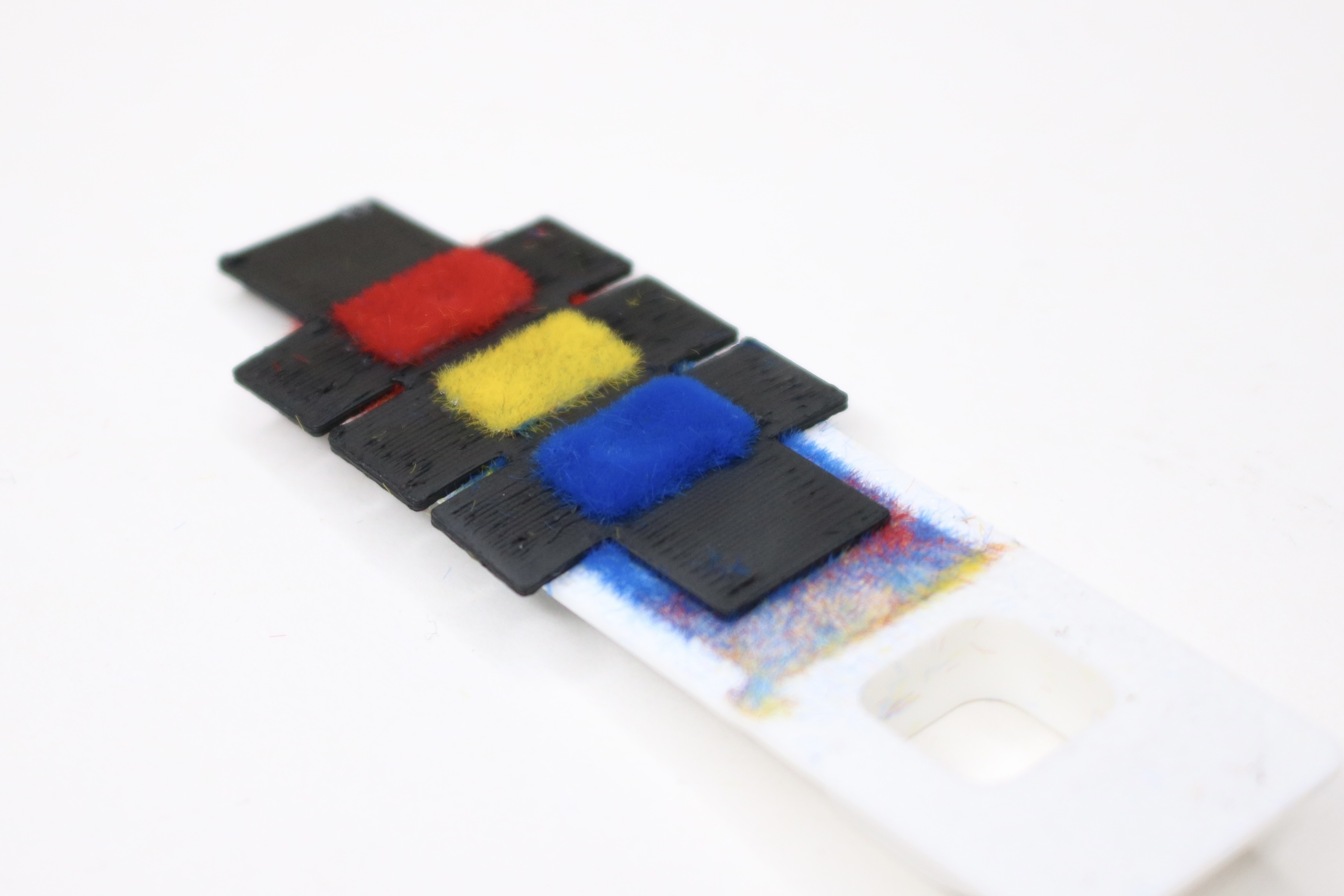 Close-up of an electrostatically flocked 3D-printed surface in three fiber colors